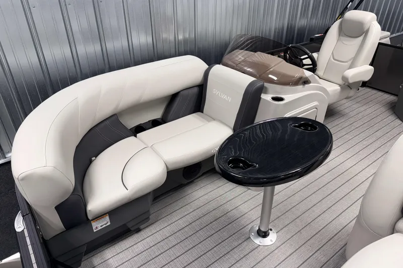 Slide: The Image of 2026 Sylvan Mirage 8520 CLZ DH boat interior with plush seating and sleek table design. - 3