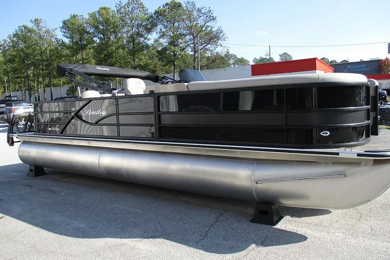 Slide: The Image of 2026 Bentley Pontoons Fish 243 N-Cruise pontoon boat in a parking lot, surrounded by trees. - 5