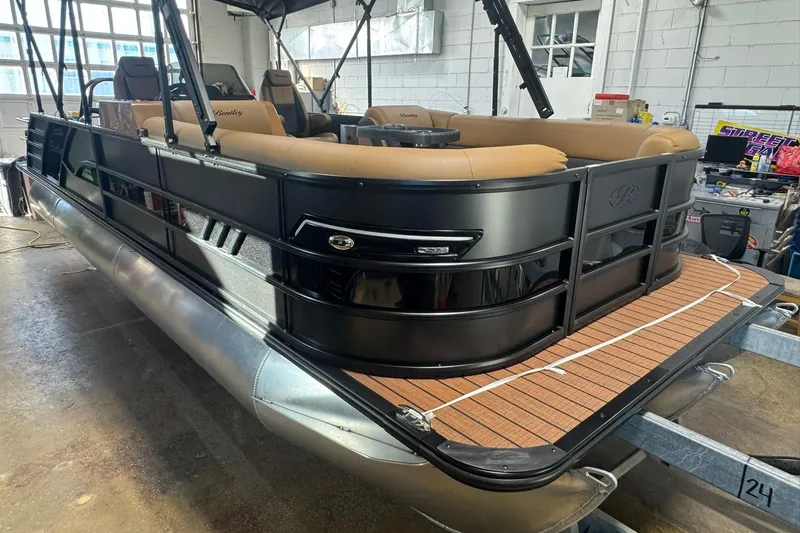 Slide: The Image of 2026 Bentley Pontoons Elite 253 Swingback in a garage, showcasing luxury design and seating. - 27