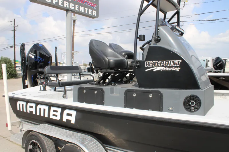 Slide: The Image of 2025 Mamba 24 Cat Classic boat interior with seating and storage, displayed outdoors. - 13