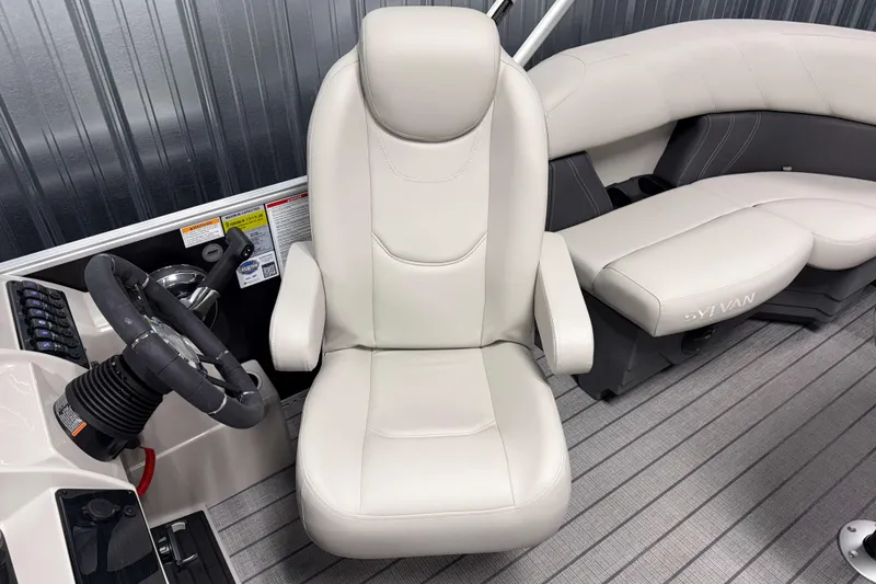 Slide: The Image of 2026 Sylvan Mirage 8520 LZ boat interior with steering wheel and plush seating. - 8