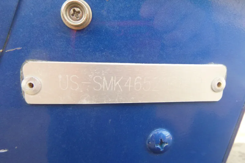 Slide: The Image of 2012 Smoker Craft Ultima 172 boat identification plate on blue surface. - 23