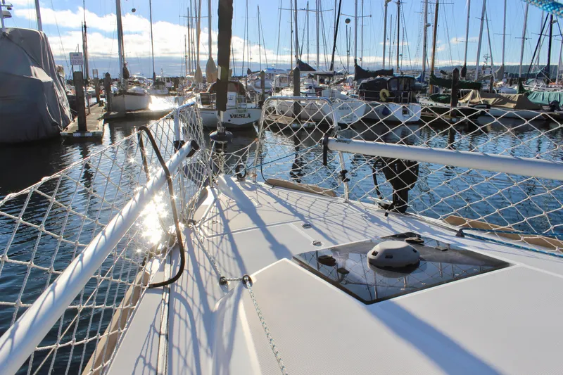 Slide: The Image of 2015 Jeanneau Sun Odyssey 349 sailboat docked in a marina, surrounded by other boats. - 11
