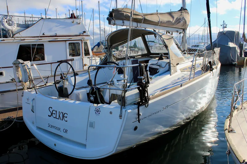 Slide: The Image of 2015 Jeanneau Sun Odyssey 349 sailboat docked in marina, rear view. - 2