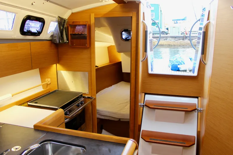 Slide: The Image of Interior of 2015 Jeanneau Sun Odyssey 349 sailboat, featuring kitchen and cozy cabin space. - 35