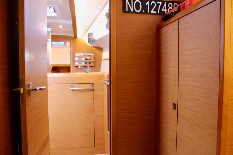 Slide: The Image of Interior of 2015 Jeanneau Sun Odyssey 349 sailboat, featuring wooden cabinetry and modern design. - 39