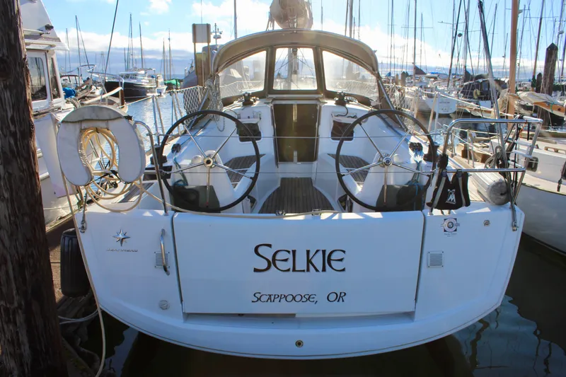 Slide: The Image of 2015 Jeanneau Sun Odyssey 349 sailboat docked, featuring dual steering wheels and "Selkie" name. - 4