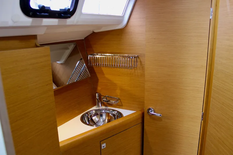 Slide: The Image of 2015 Jeanneau Sun Odyssey 349 yacht interior with wooden finish and compact sink area. - 40