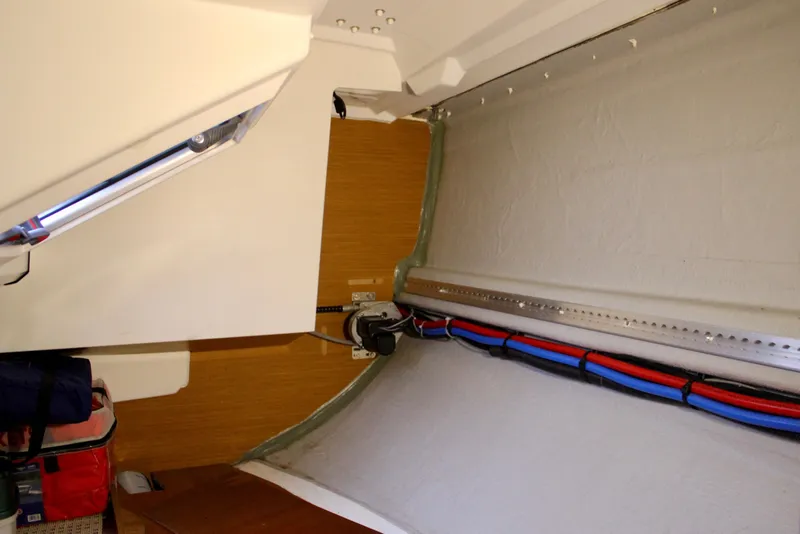 Slide: The Image of Interior view of 2015 Jeanneau Sun Odyssey 349 sailboat, showcasing wiring and storage area. - 51
