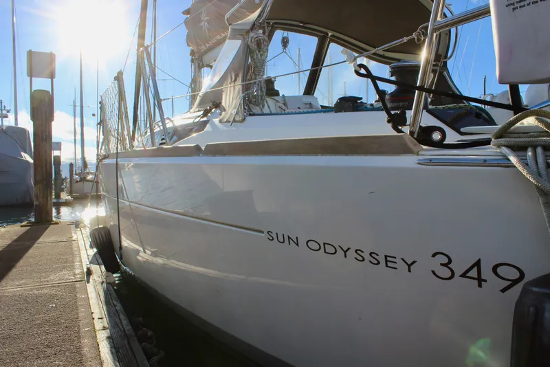 Slide: The Image of 2015 Jeanneau Sun Odyssey 349 sailboat docked in marina, sunlit and ready for sailing. - 9