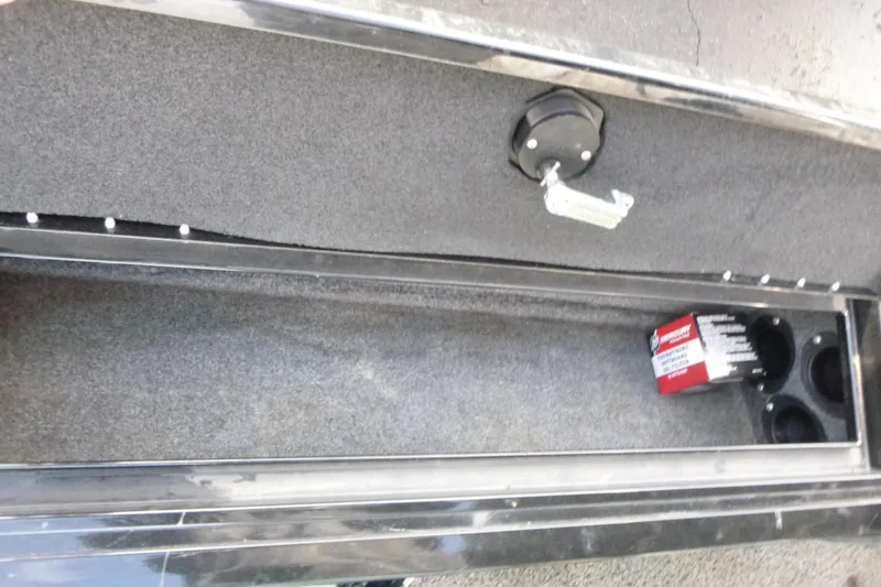 Slide: The Image of Storage compartment in 2016 Tracker Targa V-18 WT boat, featuring cup holders and a small box. - 10