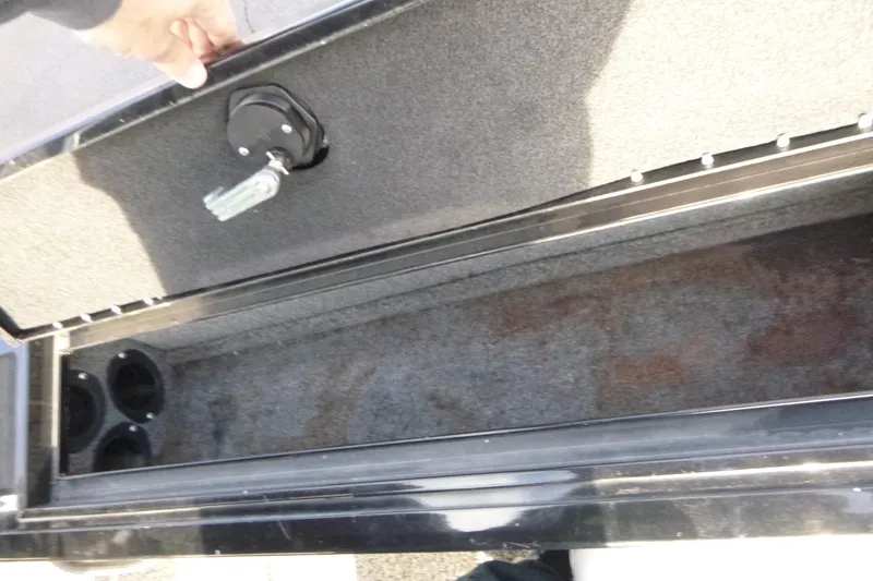 Slide: The Image of 2016 Tracker Targa V-18 WT boat storage compartment with open lid and cup holders. - 9