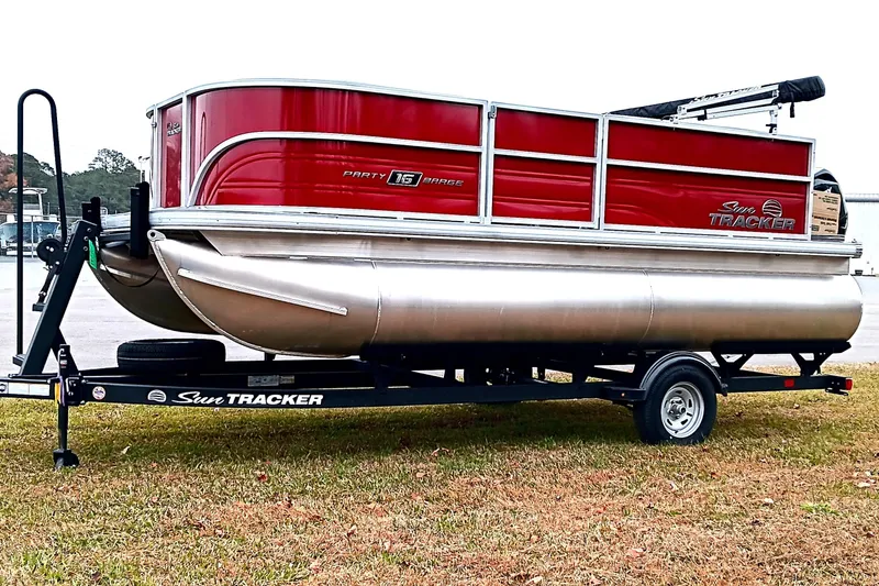 Slide: The Image of 2026 Sun Tracker Party Barge 16 DLX pontoon boat on trailer, red and silver design. - 8