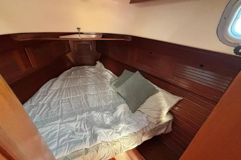 Slide: The Image of Cozy cabin interior of 1983 Bristol 38.8 sailboat with wooden paneling and bedding. - 15