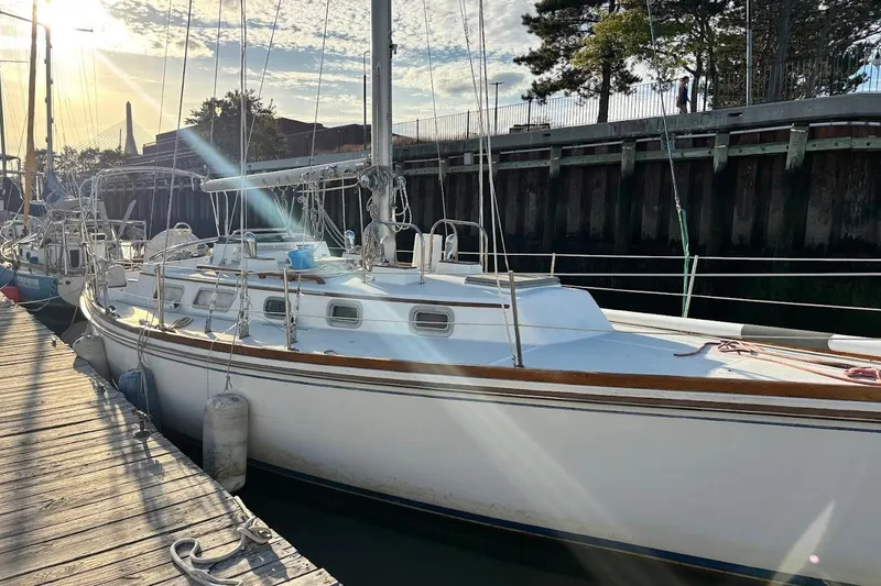 Slide: The Image of 1983 Bristol 38.8 sailboat docked at marina, sunlit with clear sky. - 2