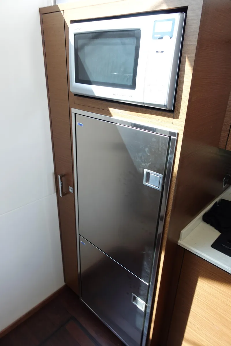 Slide: The Image of Interior of 2012 Sea Ray 450 Sedan Bridge with TV, chairs, and decorative pillows. - 26