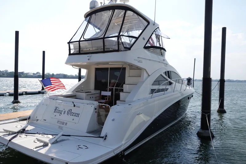 Slide: The Image of 2012 Sea Ray 450 Sedan Bridge yacht docked, featuring sleek design and American flag. - 3