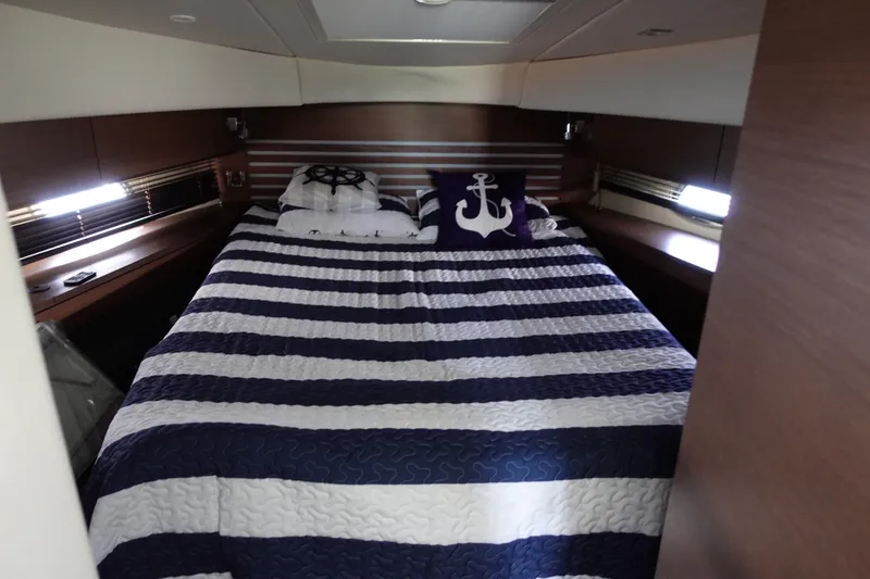 Slide: The Image of Luxurious cabin interior of 2012 Sea Ray 450 Sedan Bridge with nautical-themed bedding. - 35