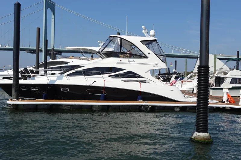 Slide: The Image of 2012 Sea Ray 450 Sedan Bridge yacht docked near a bridge on a sunny day. - 4