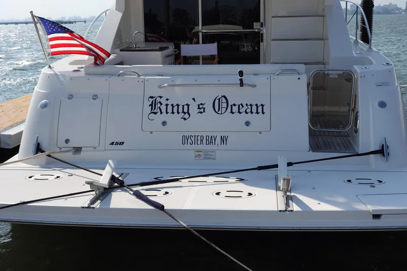 Slide: The Image of 2012 Sea Ray 450 Sedan Bridge yacht docked, featuring covered equipment and elegant deck design. - 5