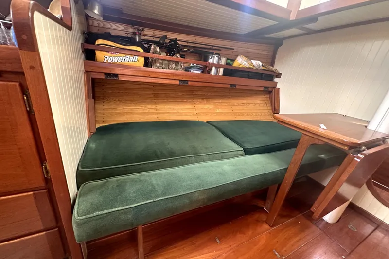 Slide: The Image of Cozy interior of 2000 Sam L. Morse Bristol Channel Cutter 28 with green cushions and wooden table. - 6