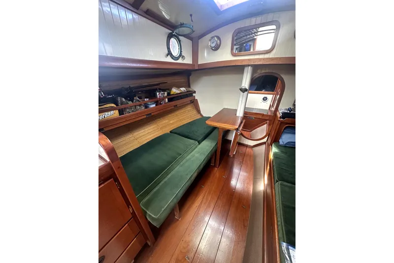 Slide: The Image of Interior of 2000 Sam L. Morse Bristol Channel Cutter 28 with wooden furnishings and green cushions. - 7