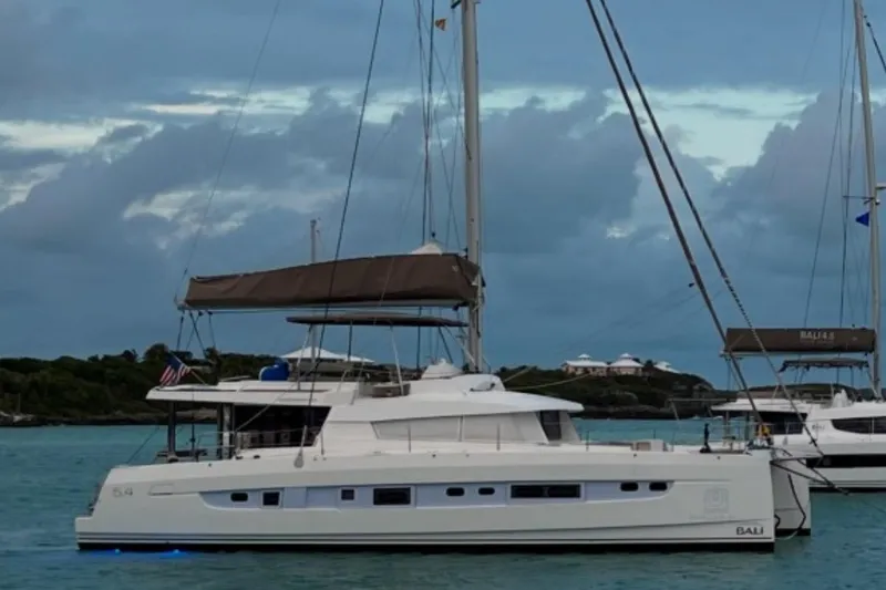 The Image of 2021 Bali 5.4 catamaran anchored in serene waters under a cloudy sky. - 1