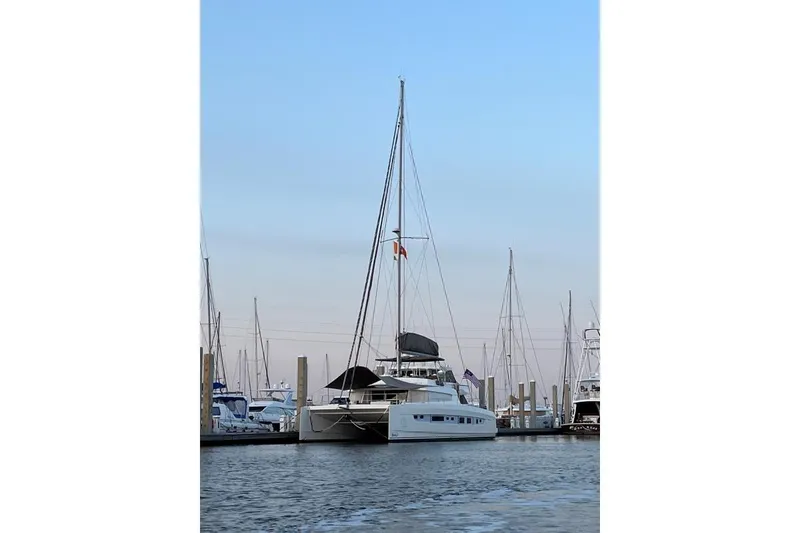 Slide: The Image of 2021 Bali 5.4 catamaran docked at marina, surrounded by sailboats under clear sky. - 3