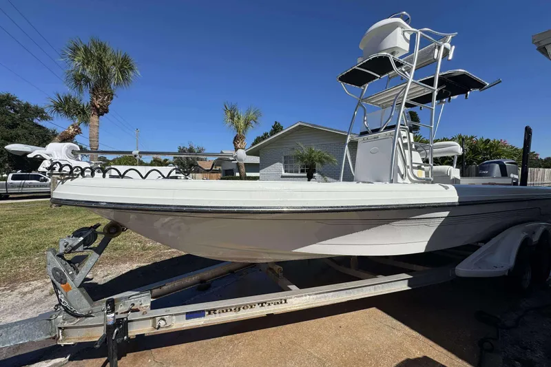 Slide: The Image of 2012 Ranger 2410 Bay Ranger boat on trailer, parked outdoors under clear blue sky. - 14