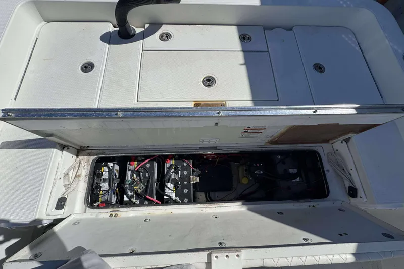 Slide: The Image of Open battery compartment of 2012 Ranger 2410 Bay Ranger boat, showing internal components. - 16