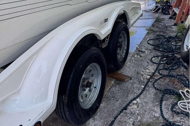 Slide: The Image of 2012 Ranger 2410 Bay Ranger trailer with dual wheels on a gravel surface. - 18