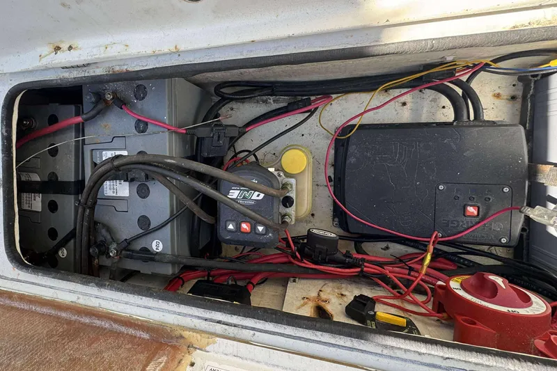 Slide: The Image of 2012 Ranger 2410 Bay Ranger boat battery compartment with wiring and components. - 24