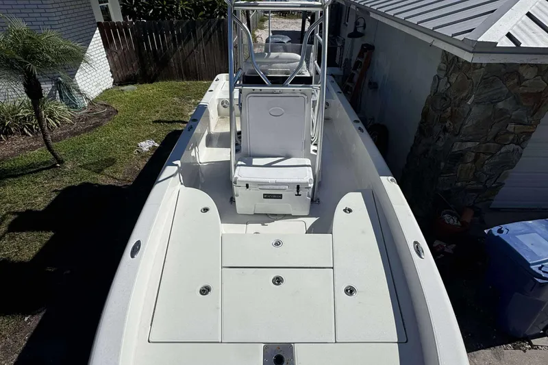 Slide: The Image of 2012 Ranger 2410 Bay Ranger boat with spacious deck and seating, parked outdoors. - 9
