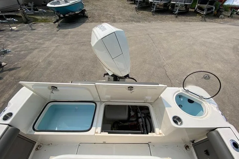 Slide: The Image of 2023 Sea Born LX22 Center Console boat with open storage compartments and motor. - 9