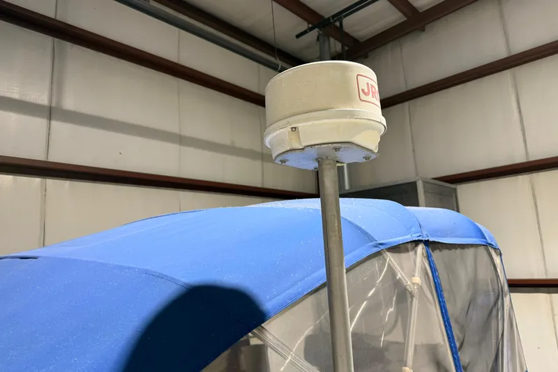 Slide: The Image of 1979 Chris-Craft 350 Catalina with blue canopy and radar equipment in a storage facility. - 11