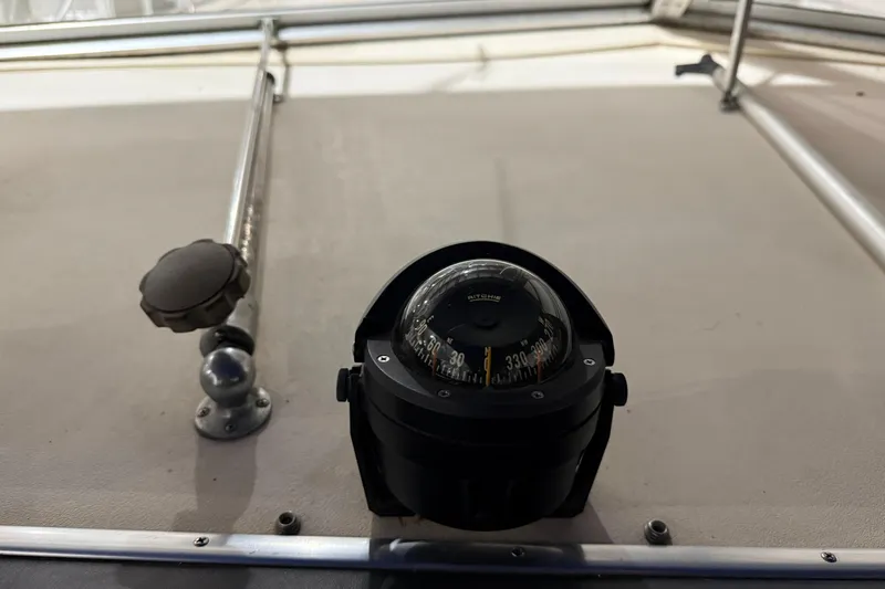 Slide: The Image of Compass on 1979 Chris-Craft 350 Catalina boat dashboard, featuring metal railings. - 13