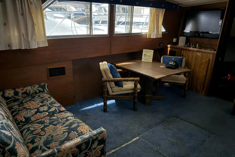 Slide: The Image of Interior of 1979 Chris-Craft 350 Catalina with floral sofa, wooden table, and nautical decor. - 6