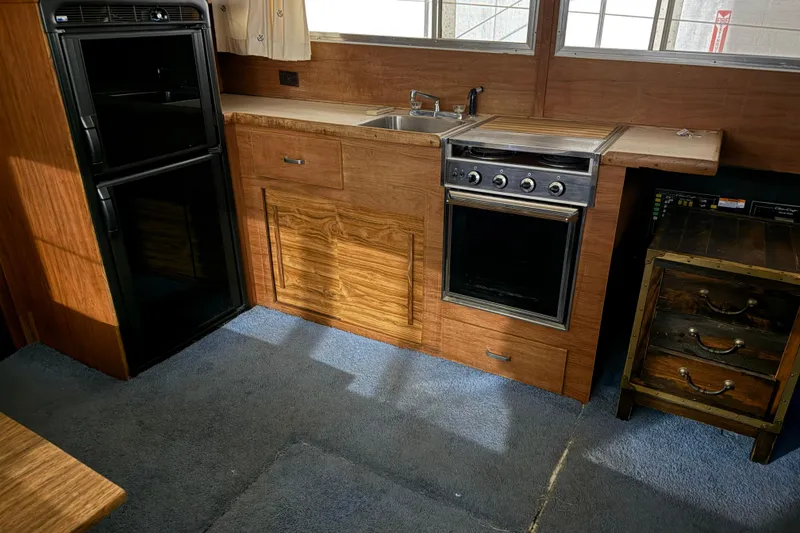 Slide: The Image of 1979 Chris-Craft 350 Catalina kitchen with wood cabinetry, stove, and refrigerator. - 8