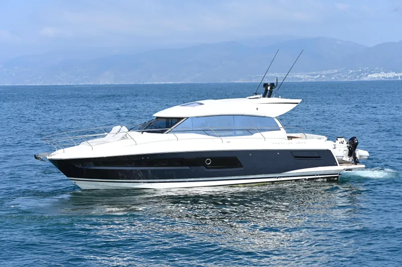 The Image of 2020 Prestige 460S yacht cruising on open water with scenic mountain backdrop. - 0