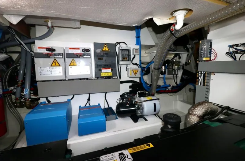 Slide: The Image of Engine room of a 2020 Prestige 460S yacht, featuring electrical panels and equipment. - 27