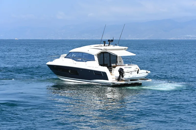 Slide: The Image of 2020 Prestige 460S yacht cruising on open water with scenic mountain backdrop. - 5