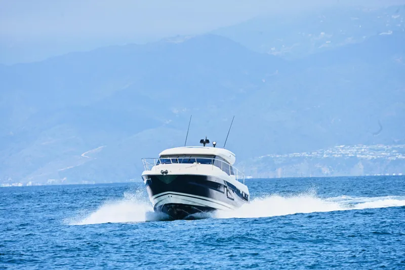Slide: The Image of Prestige 460S yacht cruising on open water with mountainous backdrop, 2020 model. - 7