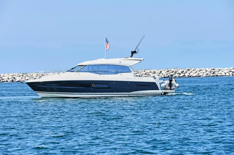 Slide: The Image of 2020 Prestige 460S yacht cruising on blue water near rocky shoreline. - 9