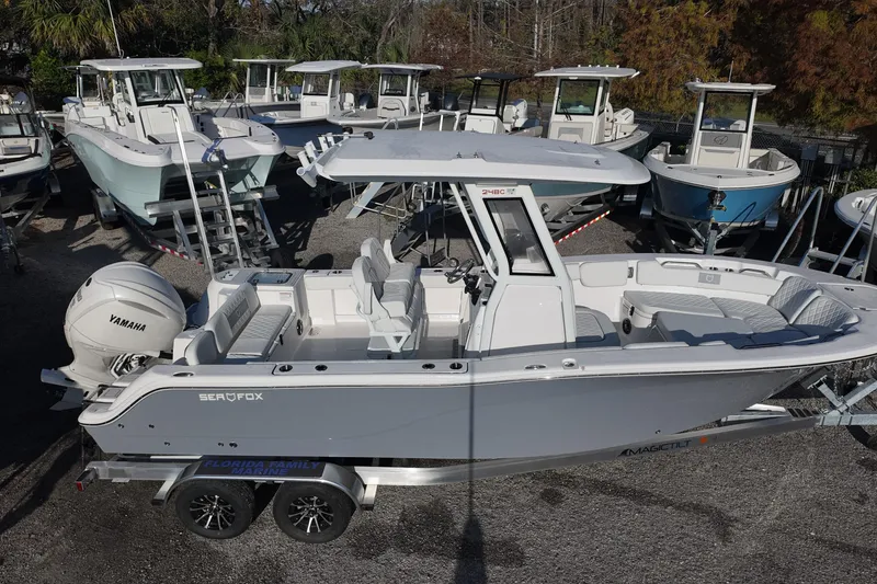 Slide: The Image of 2026 Sea Fox 248 Commander boat on trailer, surrounded by other boats in a marina. - 2