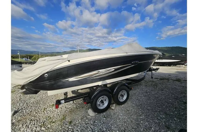 Slide: The Image of 2006 Sea Ray 220 Select boat on trailer, covered, with scenic mountain backdrop. - 1