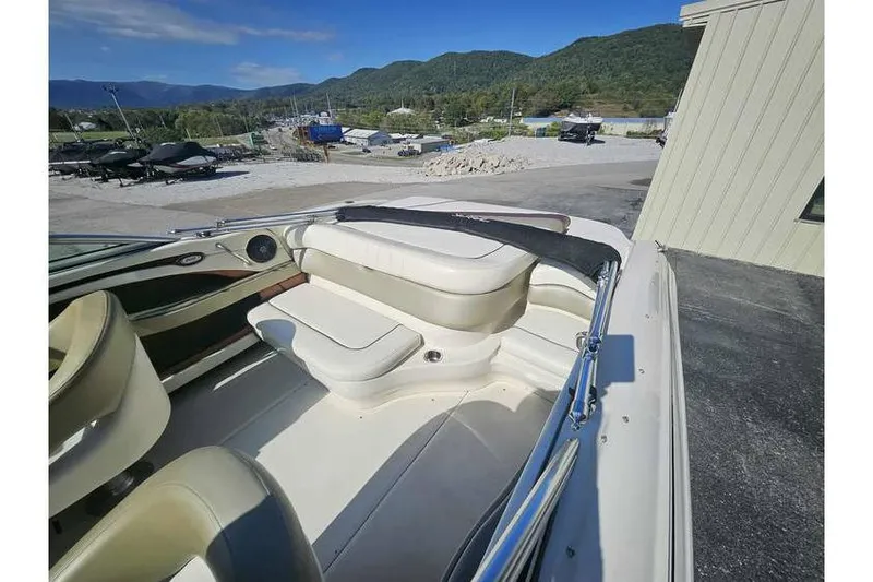 Slide: The Image of 2006 Sea Ray 220 Select boat interior with seating, parked outdoors near mountains. - 2
