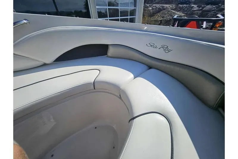 Slide: The Image of Interior seating of a 2006 Sea Ray 220 Select boat, featuring white upholstery. - 4