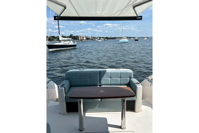 Slide: The Image of 2017 Tiara Yachts C39 Coupe with seating area overlooking a scenic marina. - 5