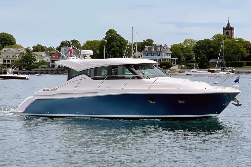 Slide: The Image of 2017 Tiara Yachts C39 Coupe cruising on a scenic waterfront with historic buildings. - 1