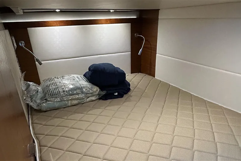 Slide: The Image of 2017 Tiara Yachts C39 Coupe cabin with beige quilted bedding and reading lights. - 16